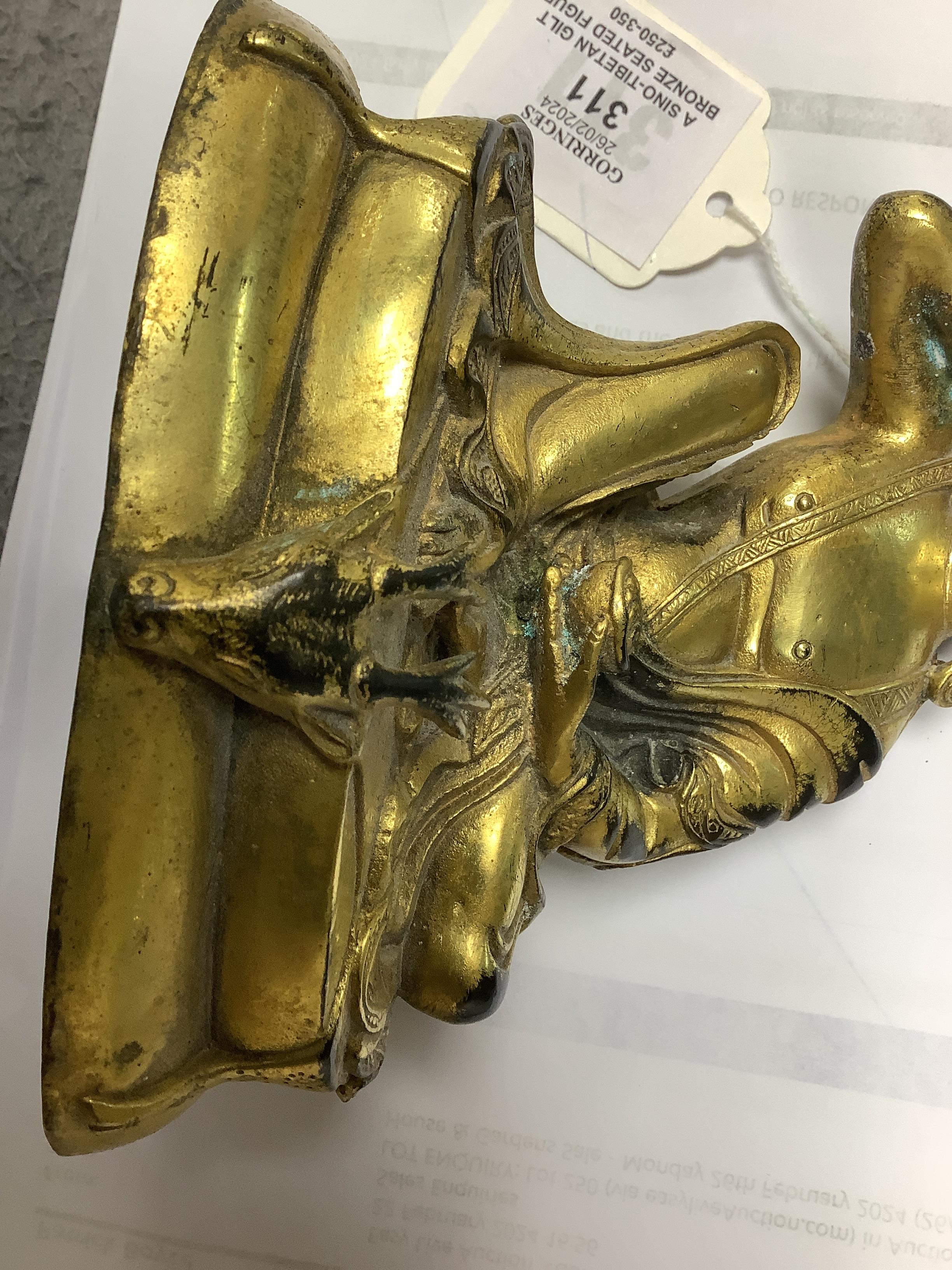 A Sino-Tibetan gilt bronze seated figure of Milarepa, 14cm high